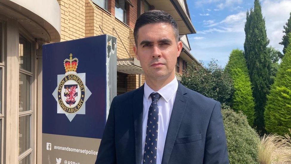 Det Insp Dan Rowan in front of an Avon and Somerset Police sign