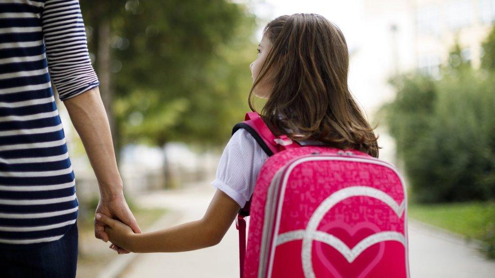 A girl holding a woman's hand