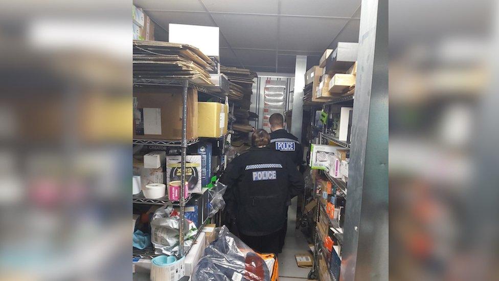 Police officers surrounded by boxes