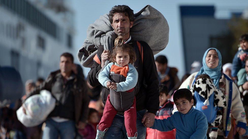 A migrant man and daughter arrives in the Greek port of Piraeus