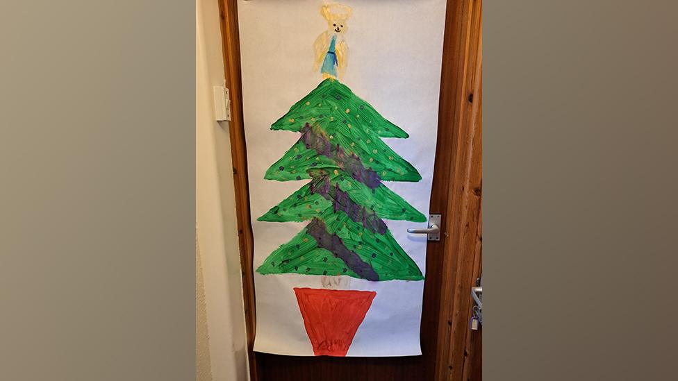 A picture of a Christmas tree on a door