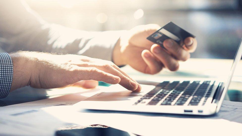 man on lap-top with bank card