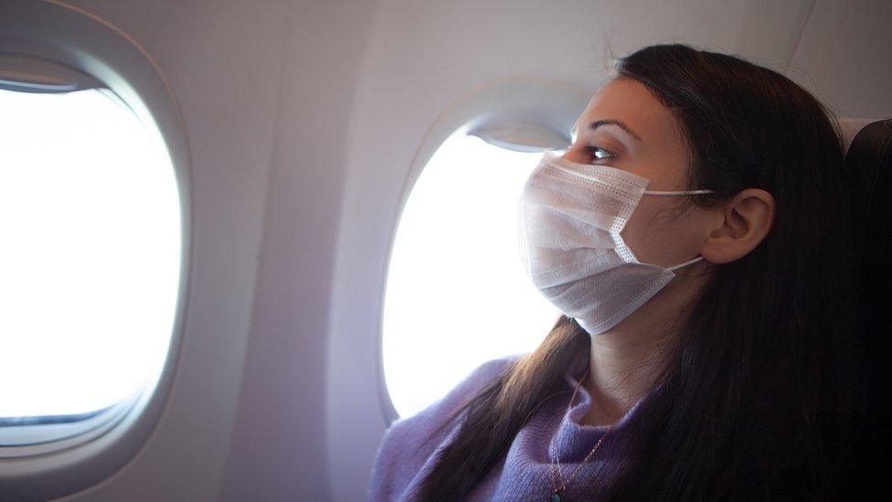 Woman wearing face mask on a plane