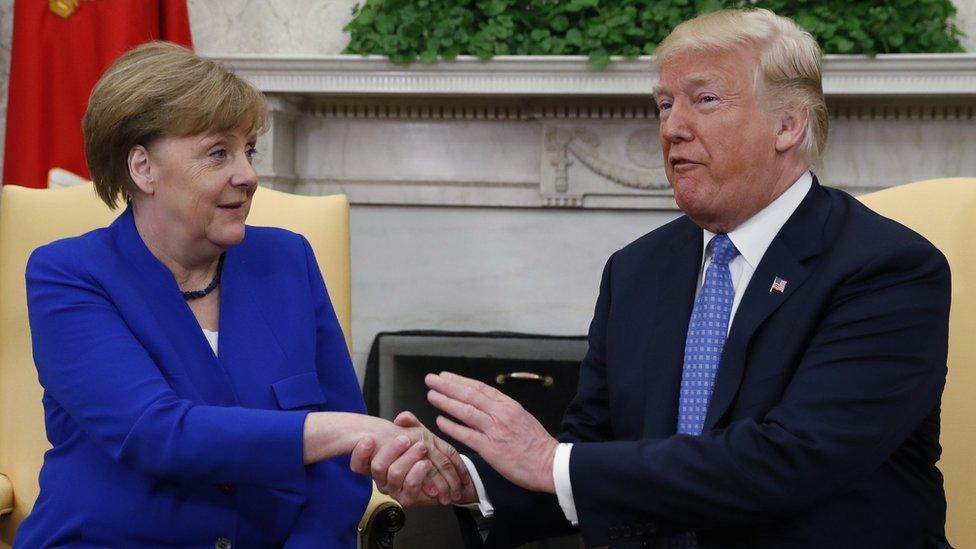 Trump shakes hands with Merkel in the Oval Office of the White House