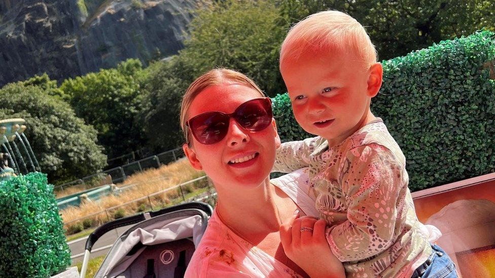 Aimee King holding her son Corey in front of Edinburgh Castle