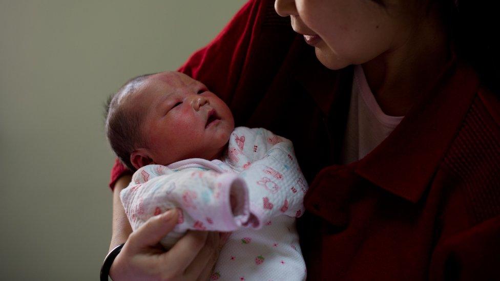 A woman holds her newborn baby girl in her room at the Antai maternity hospital in Beijing on 26 January 2012