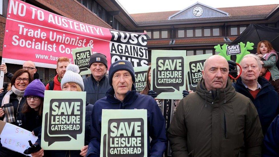 Protesters carrying banners calling for a rethink over closure plans