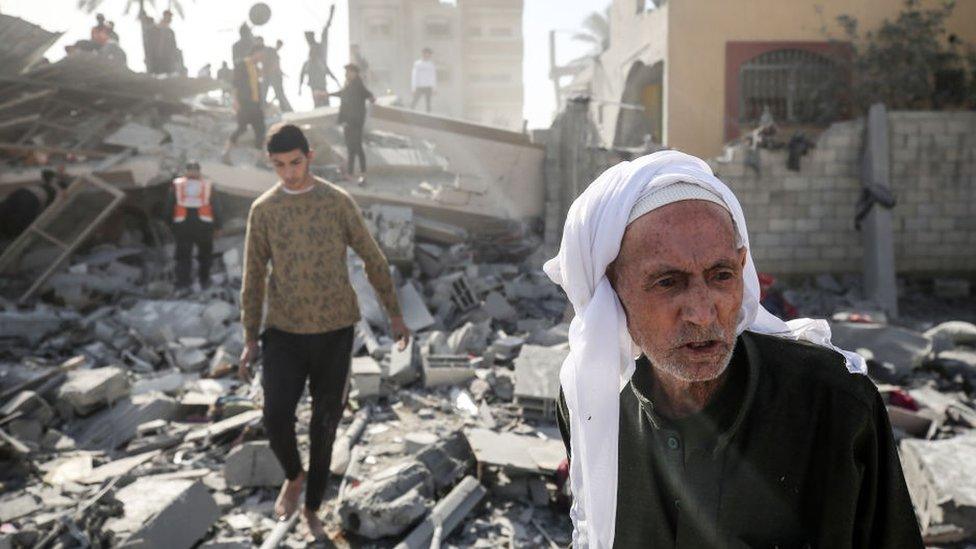 Palestinians are gathering around the destroyed home of the Hajj family following an Israeli bombardment at Nuseirat camp in the central Gaza Strip, on December 22, 2023, amid continuing battles between Israel and the militant group Hamas.