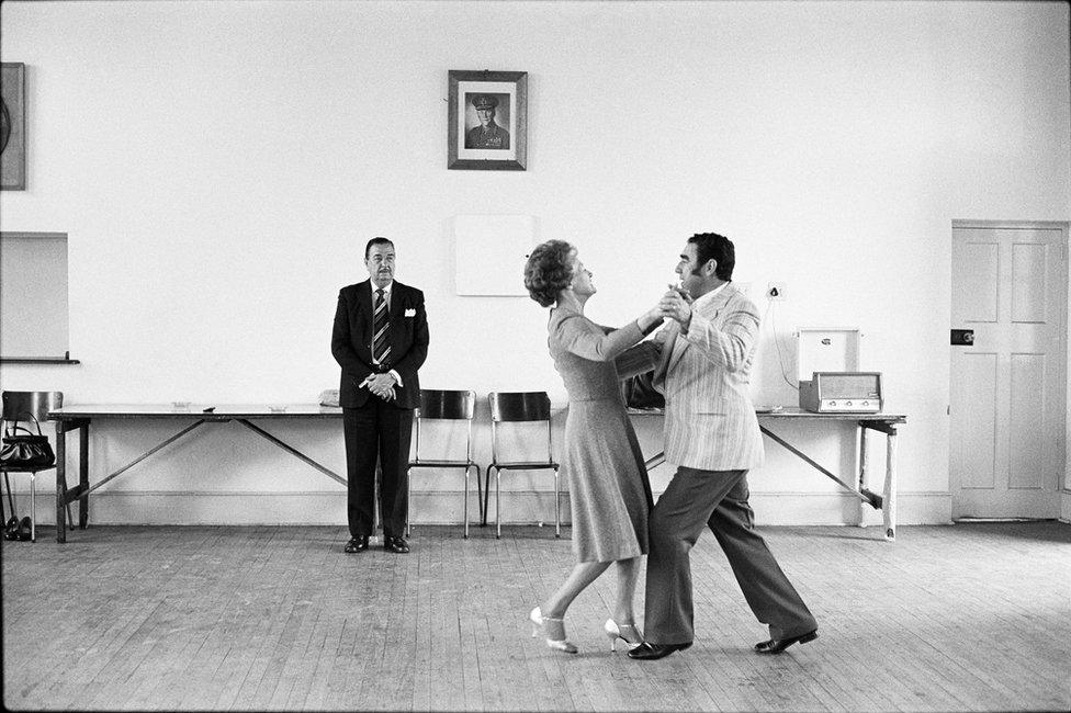 Dancing-master Ted van Rensburg watches two of his ballroom pupils, swinging to a record of Victor Sylvester and his Orchestra, in the MOTHS' Hall at the old Court House, Boksburg. 1980.