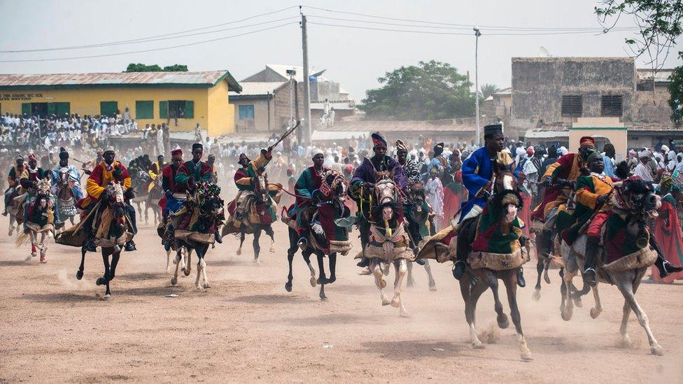 Members of the Durbar procession race the final stretch to the Emir"s palace in Kano, northern Nigeria on July 6, 2016