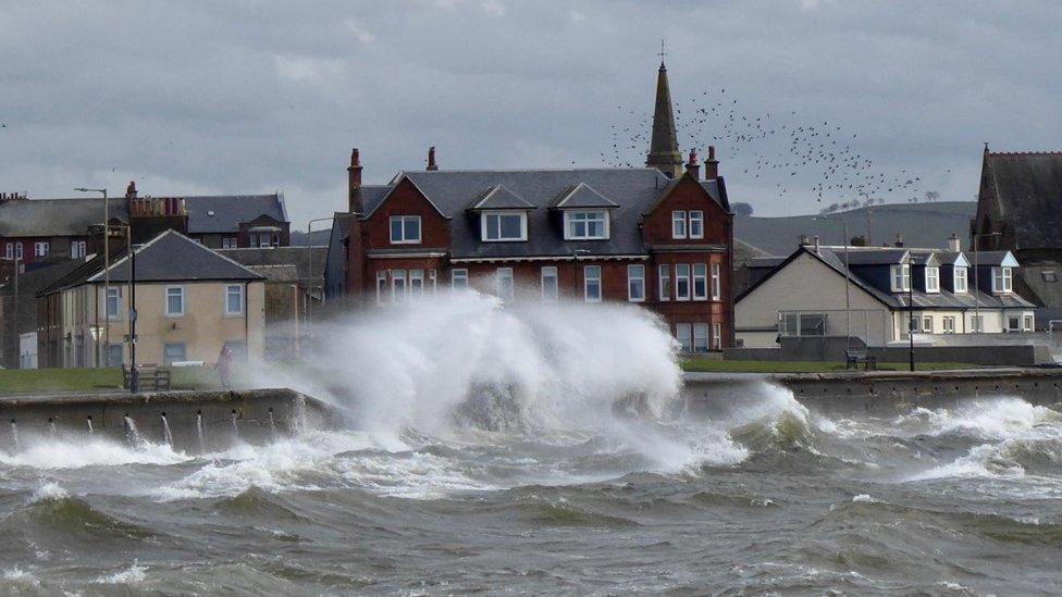 A large wave breaks in front of buildings in Troon, South Ayrshire