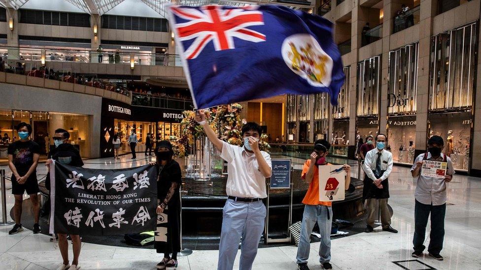 A protester waves a British colonial flag