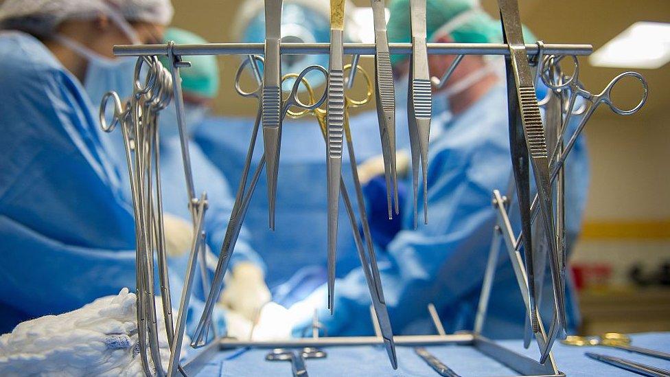 A picture shows surgical scissors and forceps during a mock surgery