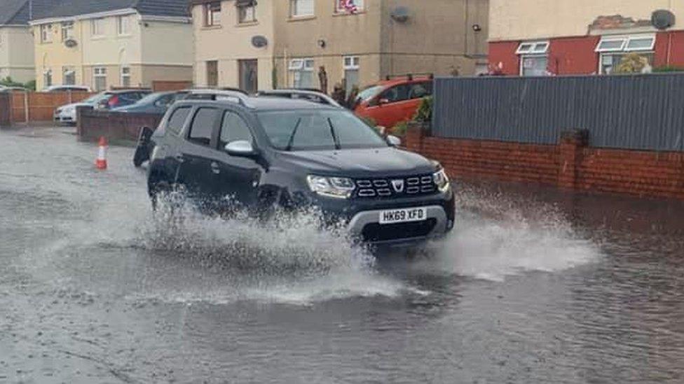 car driving through flooded street