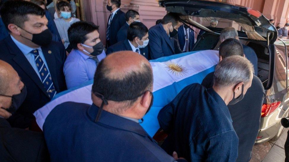 Pallbearers carry the casket of soccer legend Diego Maradona