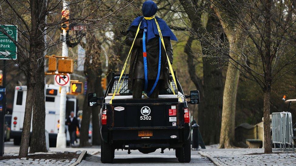 A statue of James Marion Sims is driven away after being taken down from its pedestal at Central Park, 17 April 2018