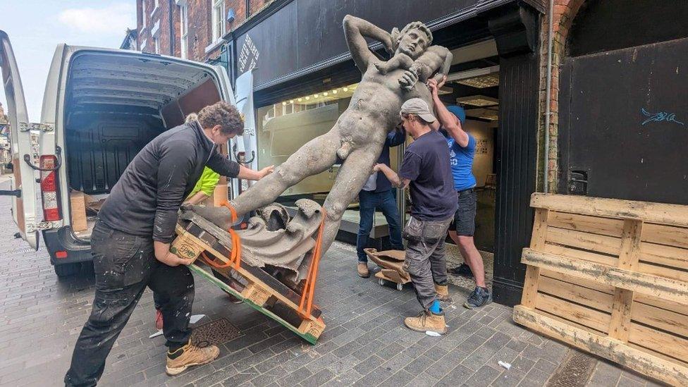 The statue being moved into the gallery