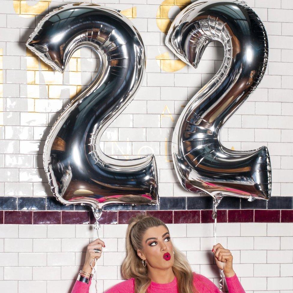 Sarah McTernan holding ballons that read out 22 - the name of her song