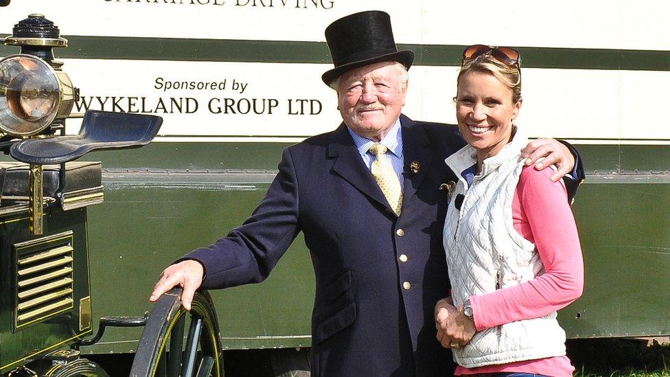 Dianne Oxberry posing with horse rider by carriage