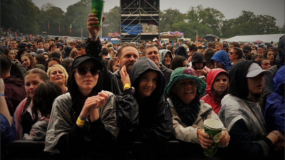 Music fans in front of a stage barrier