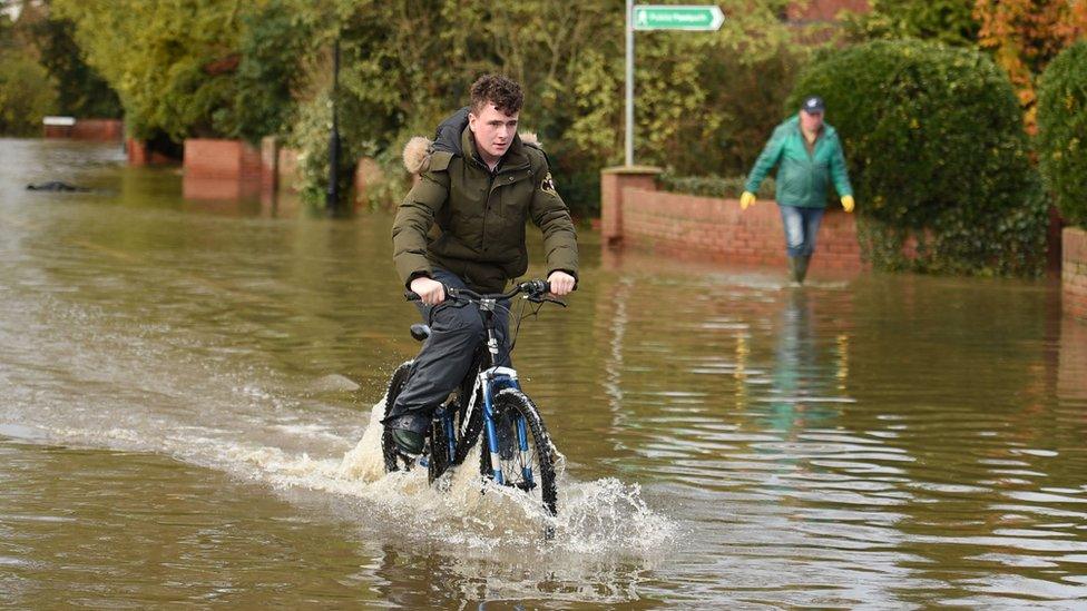 Boy cycles through water in Fishlake