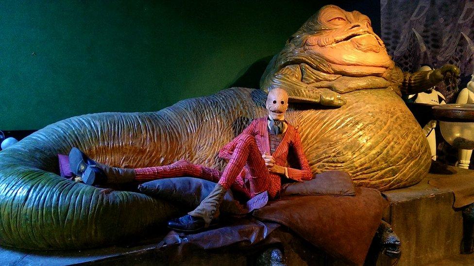 Javier lying down, in costume, next to Jaba The Hut