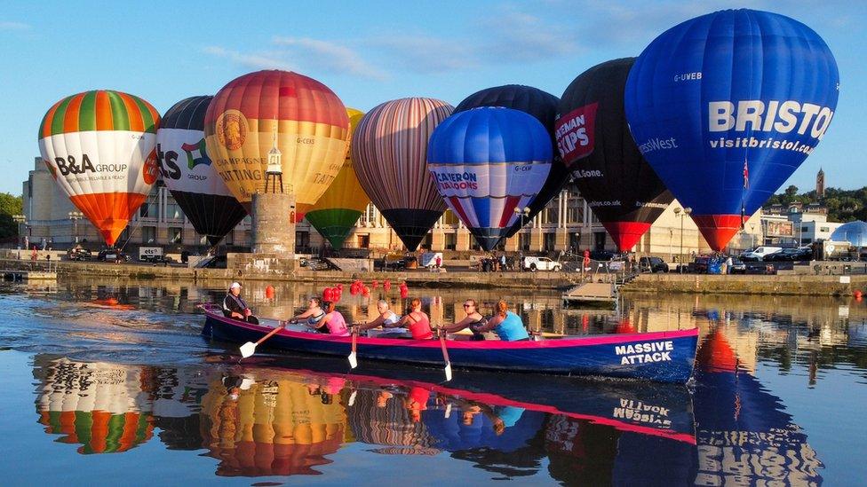 Hot air balloons inflate and tether from Bristol Harbourside