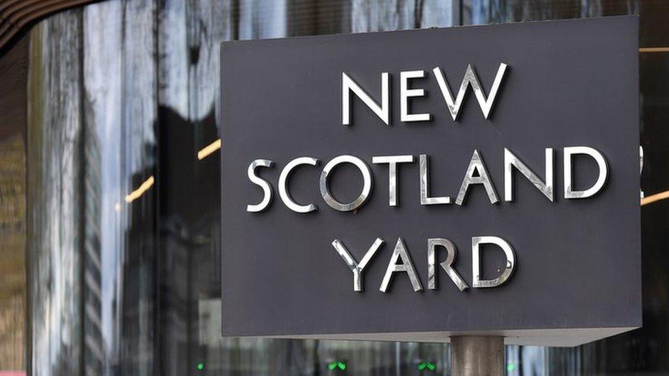 Police officers stand outside New Scotland Yard in London,