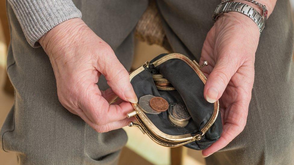 A woman looking at small change in her purse