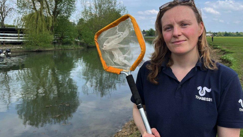 Claire Robertson standing by swimming spot with a net