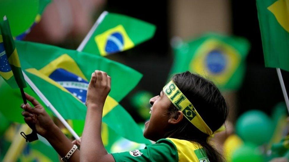 A supporter of Jair Bolsonaro waves a flag