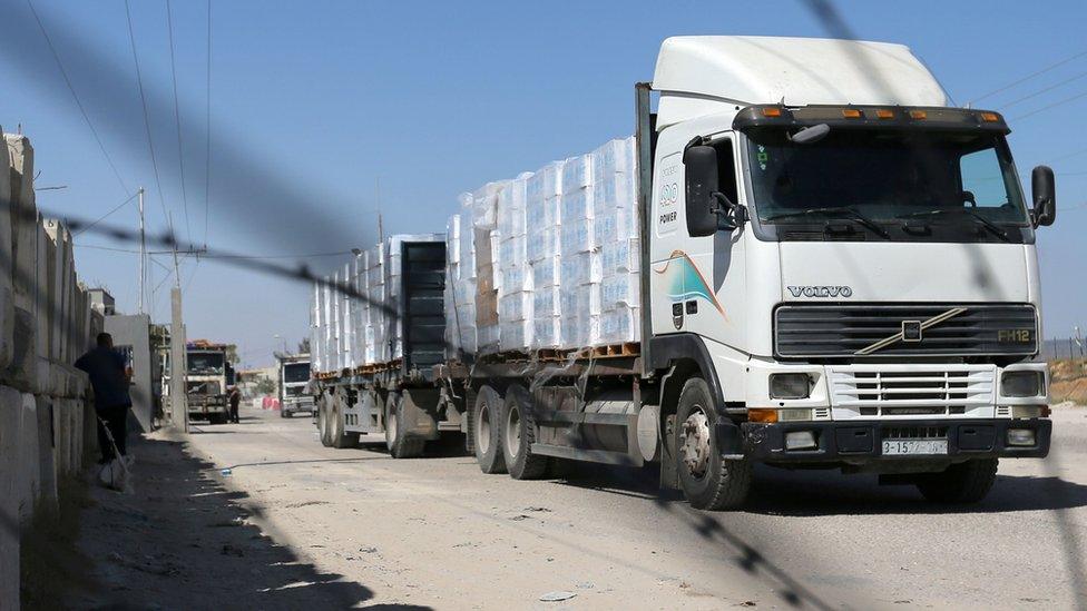 A lorry carrying goods is seen through a fence after Israel reopened the Kerem Shalom crossing with the Gaza Strip (25 May 2021)