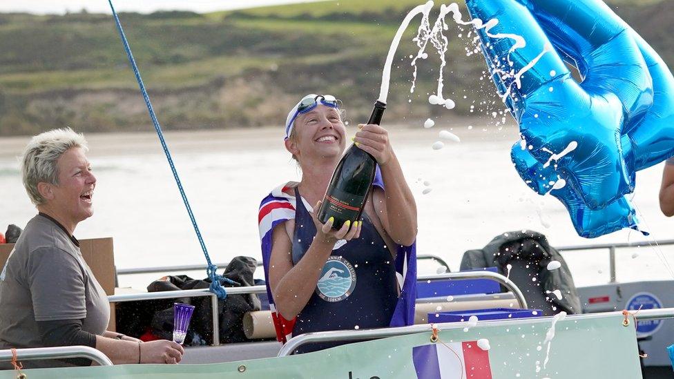 Chloe McCardel popping a champagne bottle