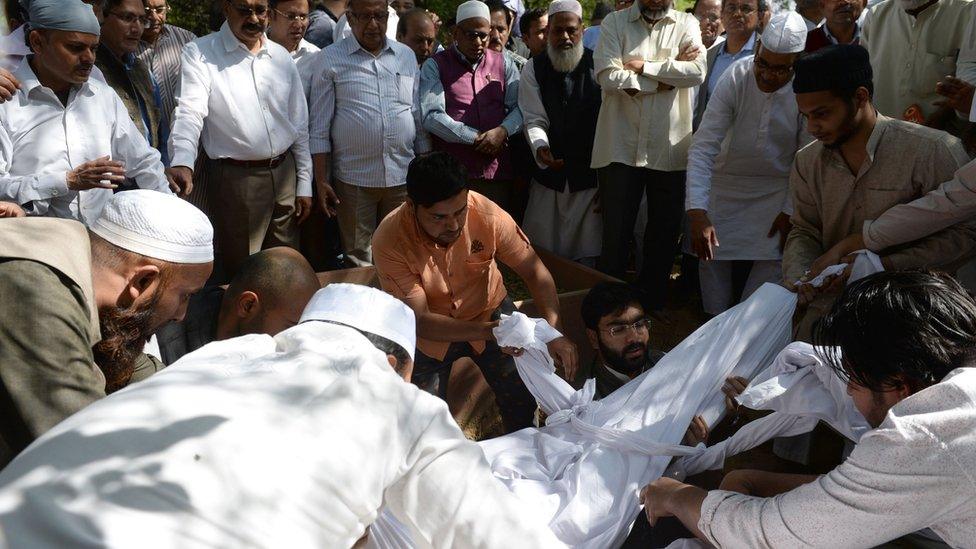 Assembled Indian Muslims bury Syed Shahabuddin, wrapped in a shroud, in New Delhi on March 4, 2017