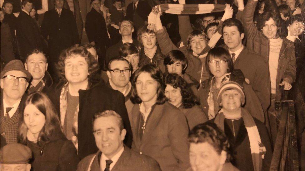 A crowd of Boro fans including a young Ali