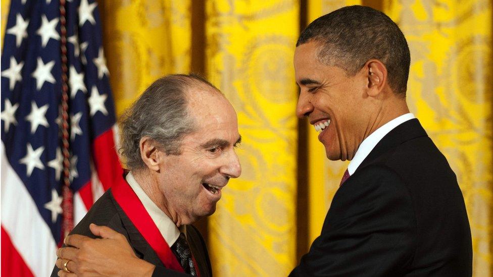 Philip Roth smiling while receiving the National Humanities Medal from then President Barack Obama in 2011