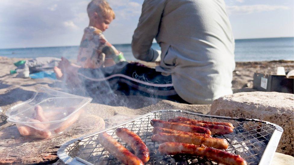 boy-and-dad-next-to-disposable-barbecue.