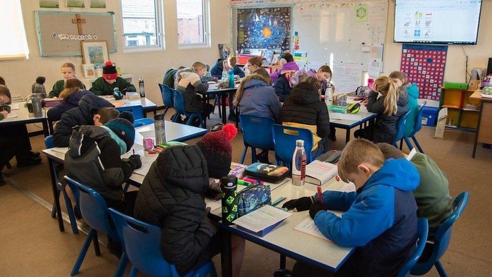 Children in classroom wearing coats