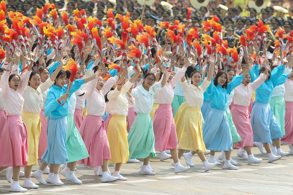 Performers walk and dance during the parade for the 70th anniversary of the establishment of the People's Republic of China, 1 October 2019 in Tiananmen Square.