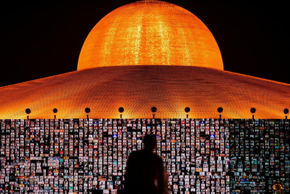 People pray as screens show devotees gathering via Zoom application during a ceremony to commemorate the Buddhist Lent Day at the Wat Phra Dhammakaya temple, amid the coronavirus disease (COVID-19) outbreaks, in Pathum Thani province, Thailand, July 24, 2021.