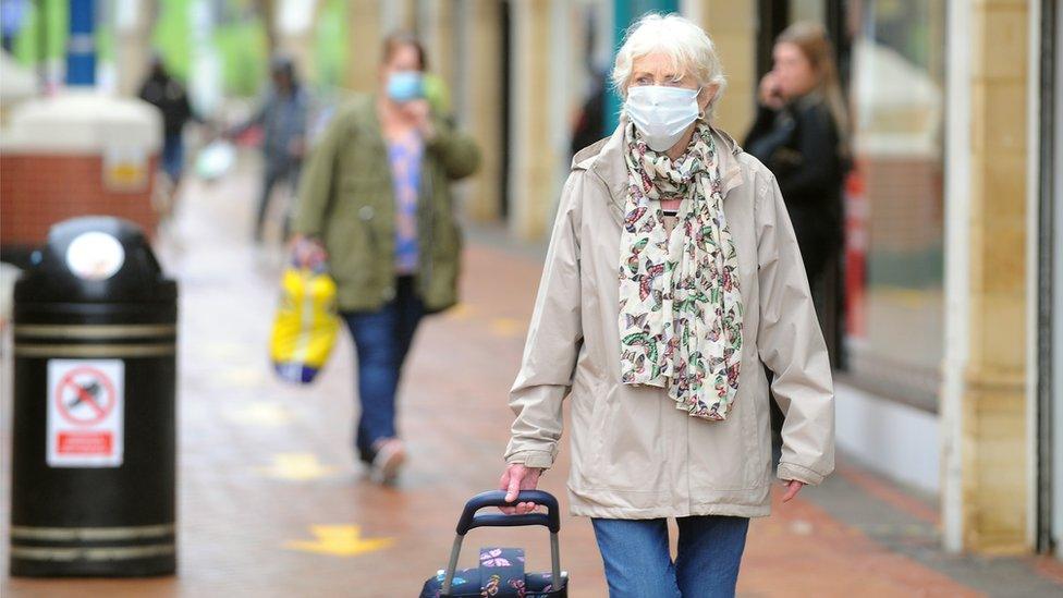 Woman wearing a face covering shopping in Caerphilly