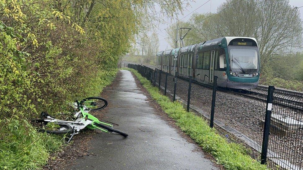 A fallen bike at the side of the a pavement