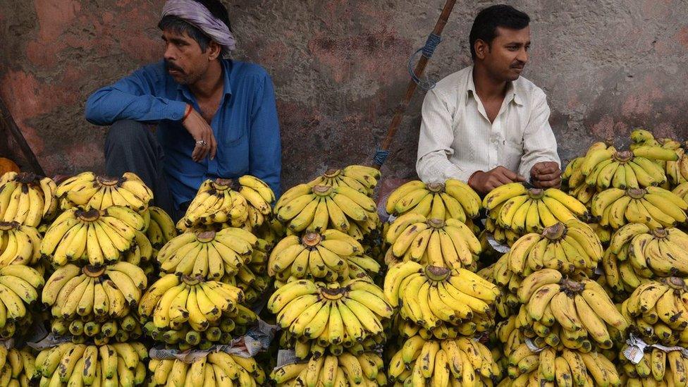 Two men selling bananas