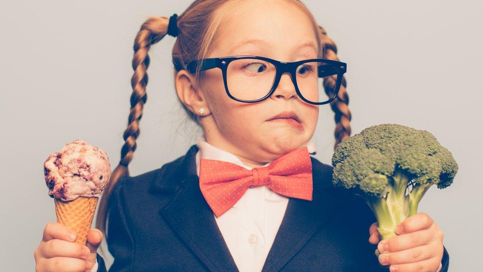 Girl deciding between ice cream and broccoli