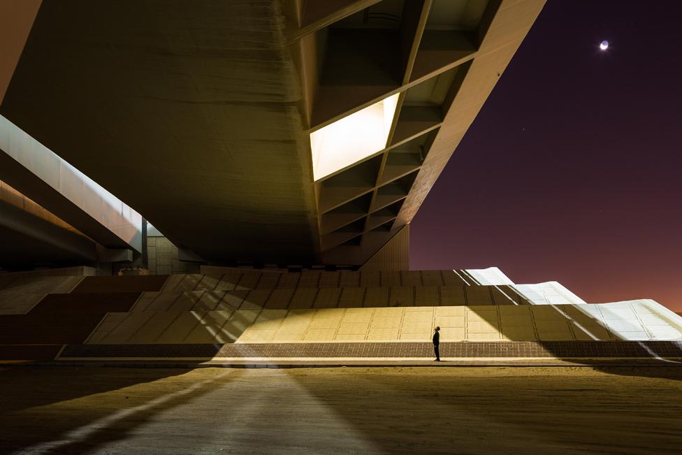 A person looking up at a building.