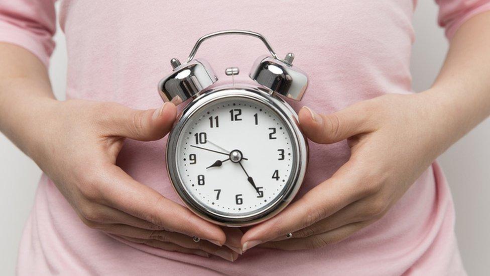 person holding alarm clock