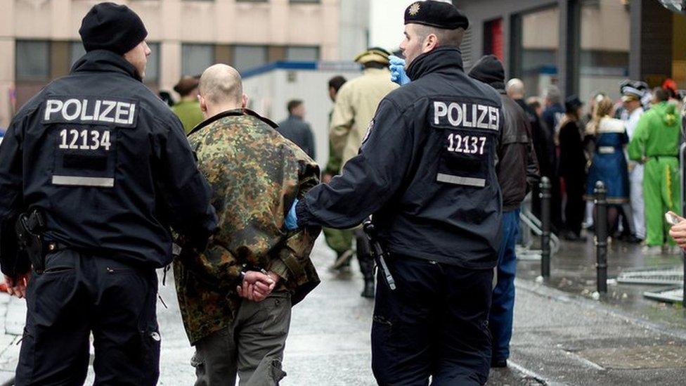 Policemen arrest a man during Weiberfastnacht celebrations as part of the carnival season on February 4, 2016 in Cologne, Germany.