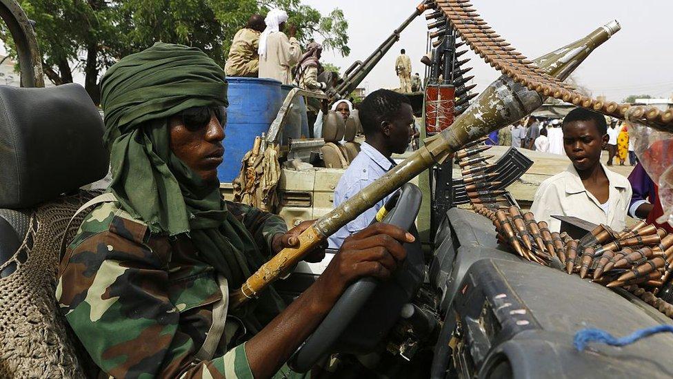 A fighter from the Sudanese Rapid Support Forces sits in an armed vehicle in the city of Nyala, in south Darfur, on May 3, 2015, as they display weapons and vehicles they say they captured from Dafuri rebels and fighters from The Justice and Equality Movement (JEM), lead by opposition leader Jibril Ibrahim, the previous week