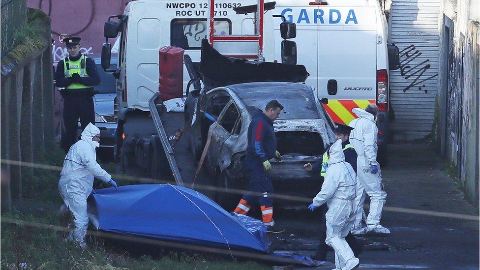 Gardaí at the scene of the burn-out vehicle in Dublin