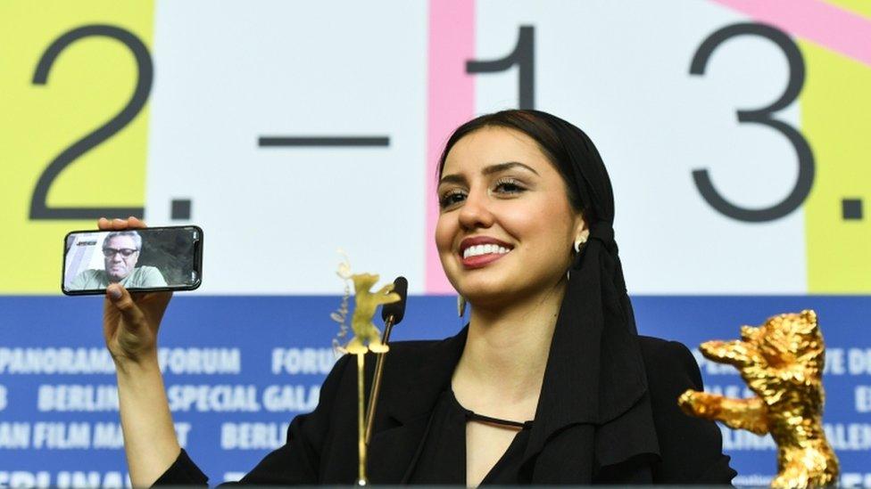 Director Mohammad Rasoulof speaks through a video call on a mobile phone held by his daughter, Baran Rasoulof